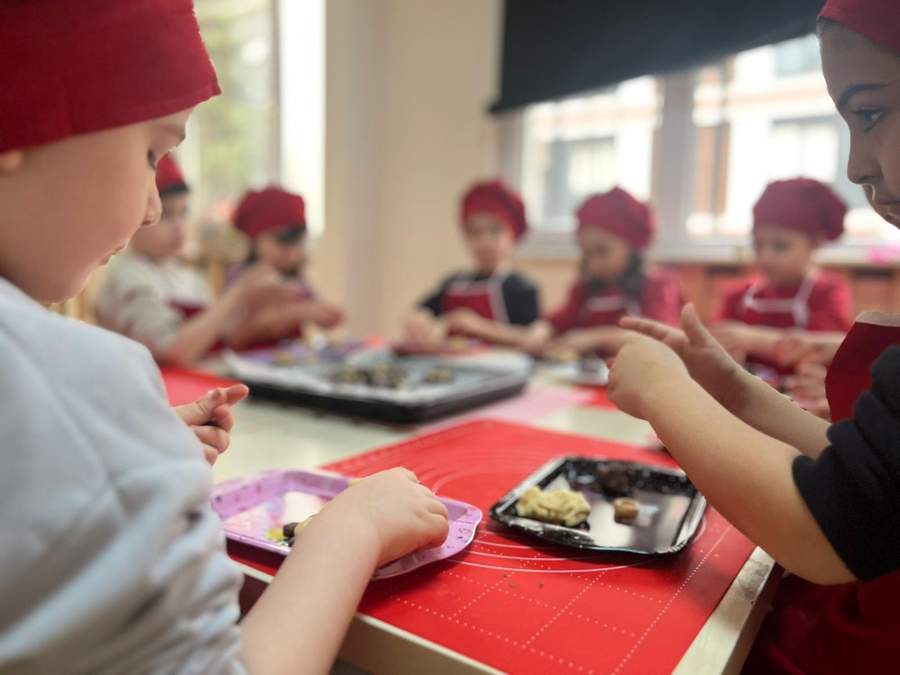 Mutfak atölyesinde birlikte alkışlayan çocuklar