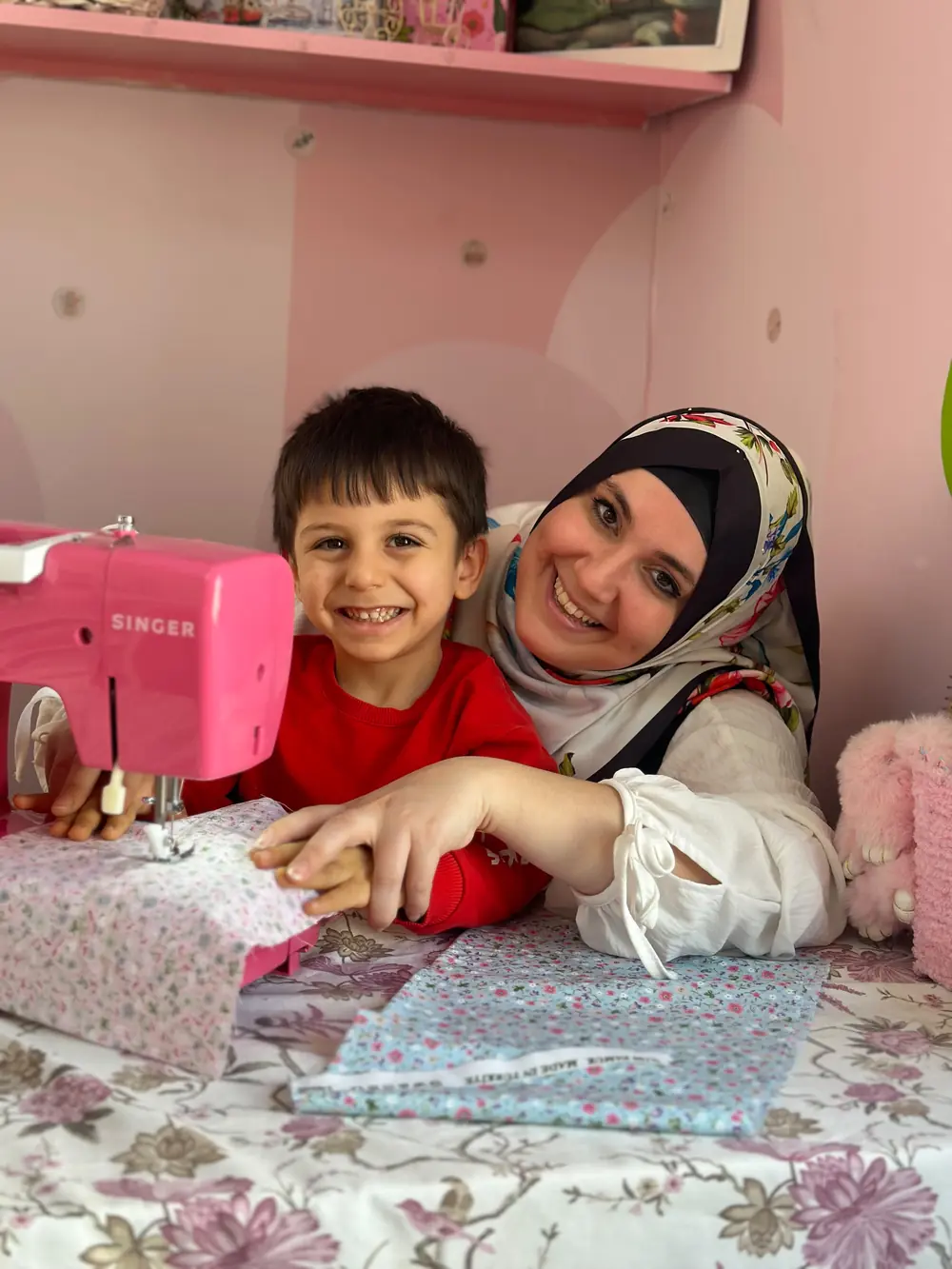 Anne ve çocuğun terzi atölyesinde birlikte dikiş yapması